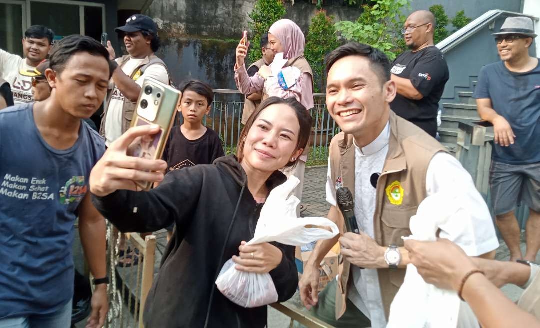 Ben Kasyafani membagikan daging kurban di Kantor DPP LDII. Banyak ibu-ibu muda gemes dan mengajaknya berswa foto. (Foto: Asmanu Sudarso/Ngopibareng.id)