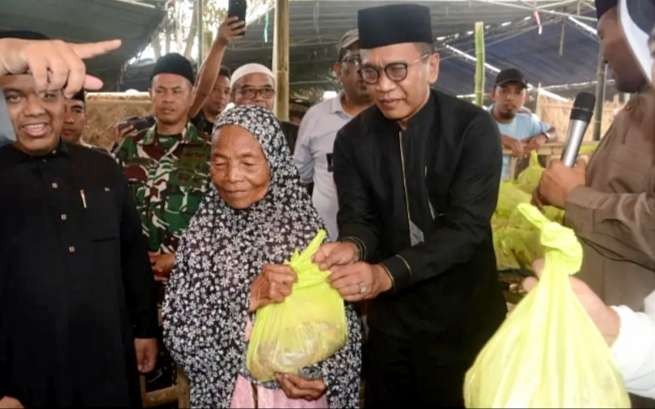 Pj Bupati Bondowoso Bambang Soekwanto didampingi Pimpinan Pon pes Al Ishlah membagikan kantong daging korban. (Foto: Guido/Ngopibareng.id)