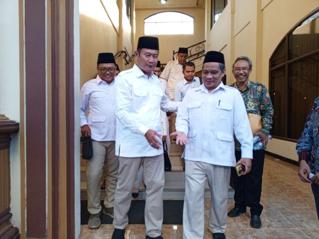 Bupati Lamongan, Yuhronur Efendi menuruni tangga bersama Ketua DPC Gerindra Lamongan Raden Imam Mukhlisin  usai Rapimcab (Foto :Imron Rosidi/ngopibareng.id)