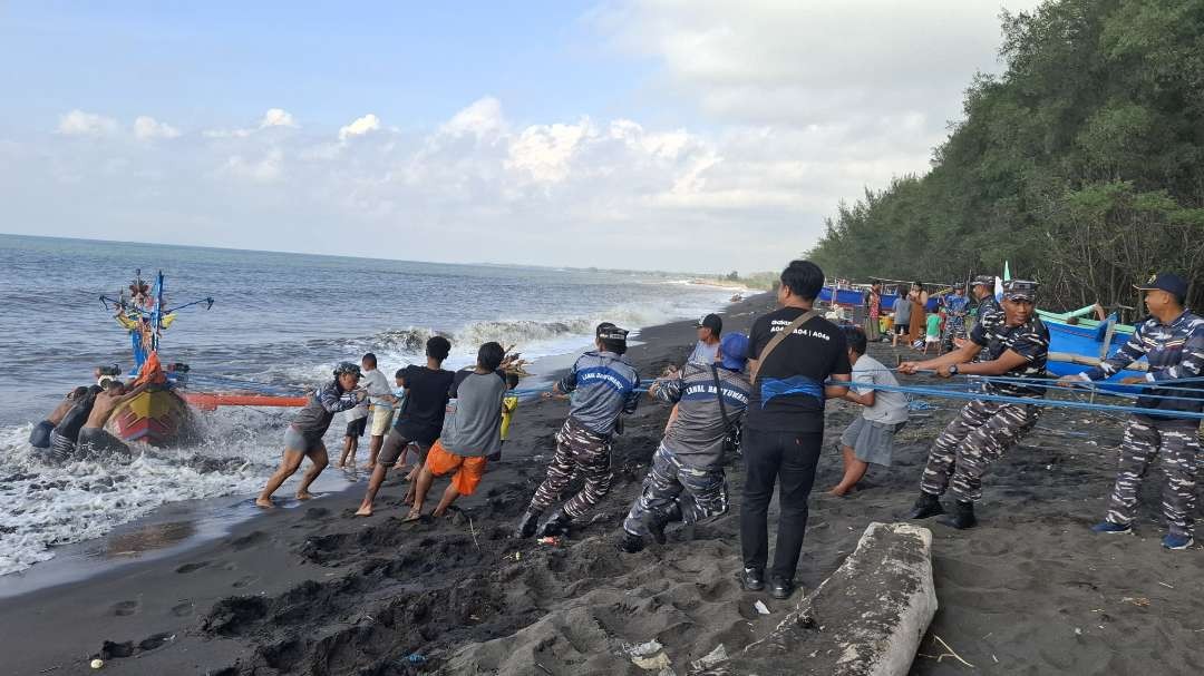 Prajurit Lanal Banyuwangi dan siswa Kodiklatal bahu membahu menarik perahu yang ditumpangi korban. (Foto: Istimewa)