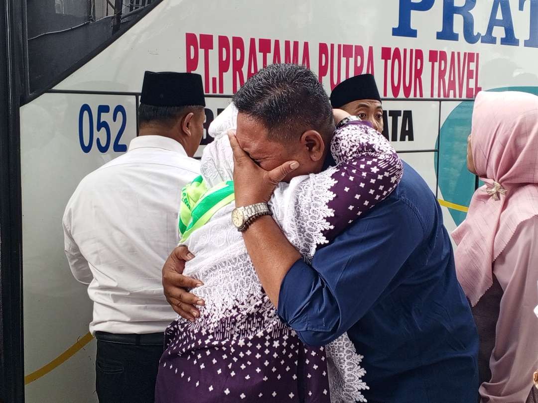 Jemaah haji yang datang langsung berpelukan dengan keluarga diwarnai isak tangis. (Foto: Imron Rosidi/Ngopibareng.id)