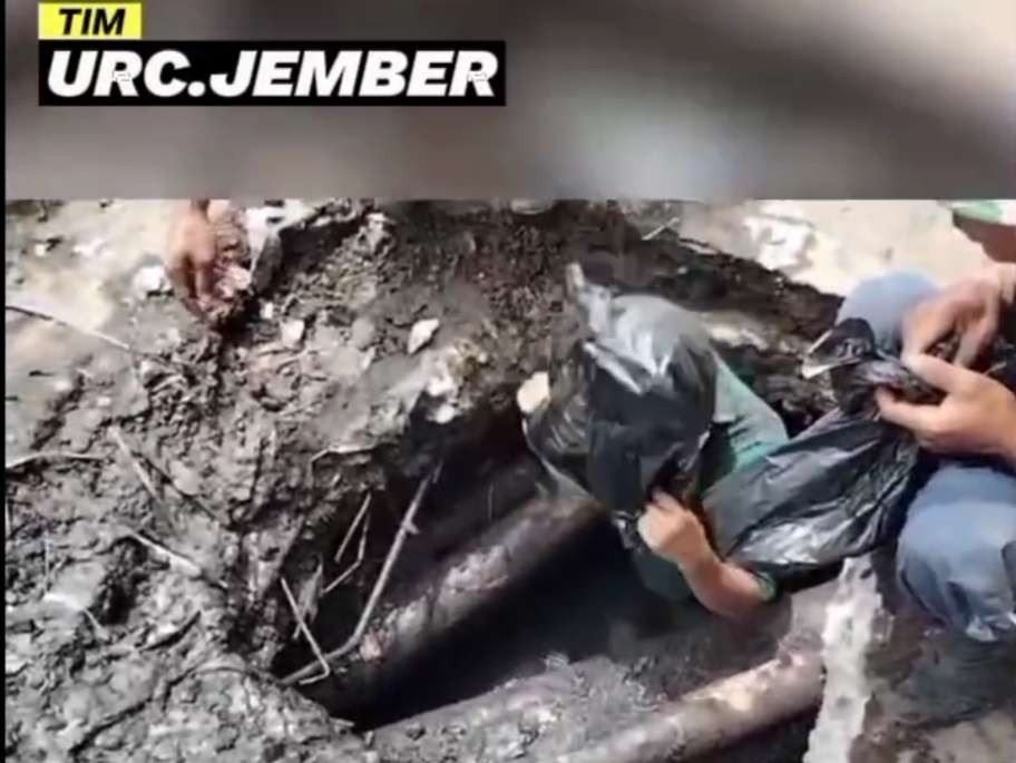 Petugas TURC Jember saat masuk ke dalam gorong-gorong hanya dengan menggunakan penutup kepala dari plastik (Foto: Tangkap layar video)