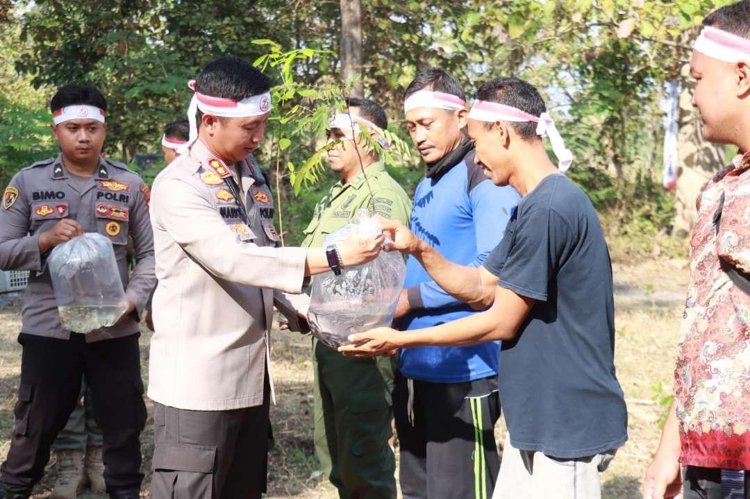 Kapolres Bojonegoro, AKBP Mario Prahatinto, saat memberikan bibit lele kepada mastarakat di Dander, Bojonegoro pada Kamis 27 Juni 2024. (Foto: polres bojonegoro)