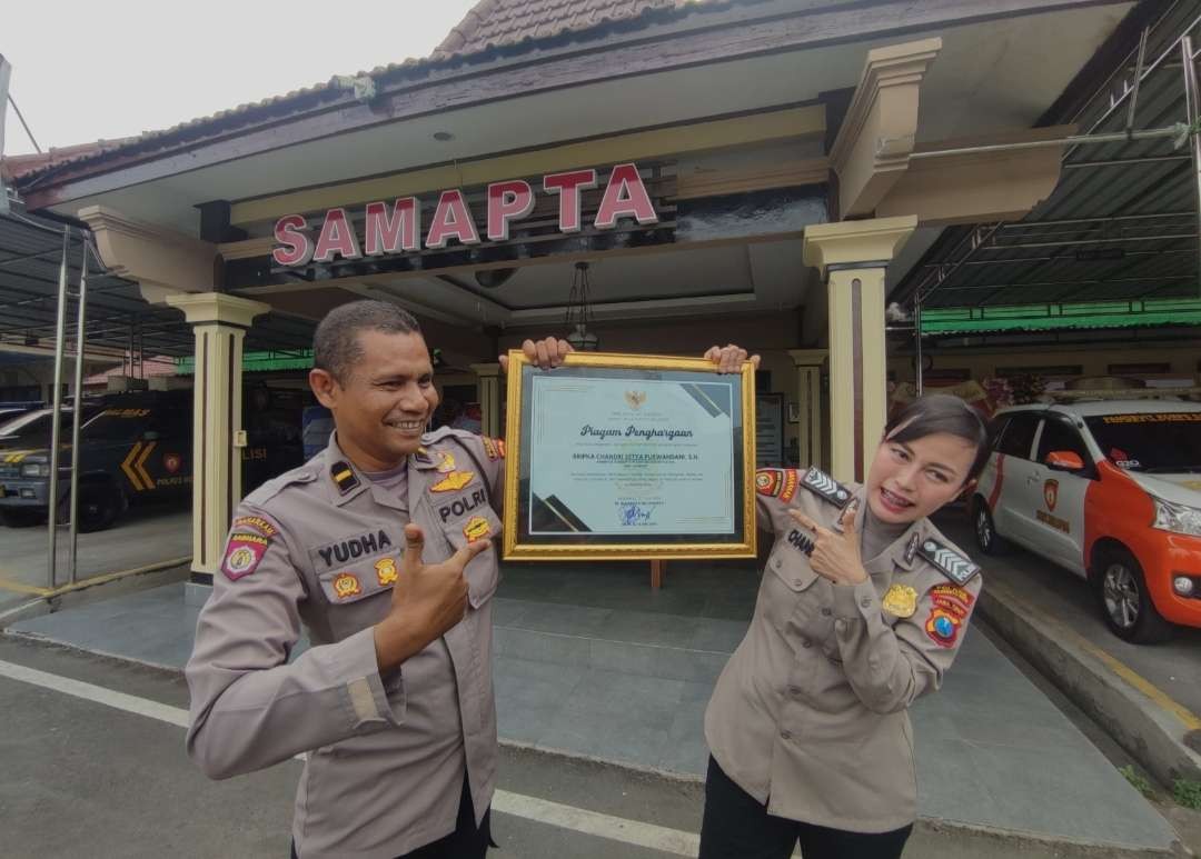 Kanit Turjawali Satsamapta Polres Mojokerto Kota, Ipda Iswahyuda bersama Bripka Chandri Setya Purwandani menunjukkan piagam penghargaan. (Foto: Deni Lukmantara/Ngopibareng.id)