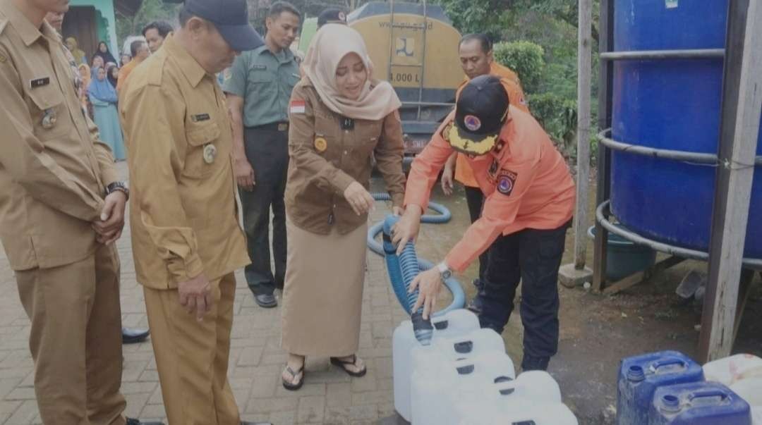 Bupati Ikfina saat menyalurkan bantuan air bersih.(Foto istimewa)