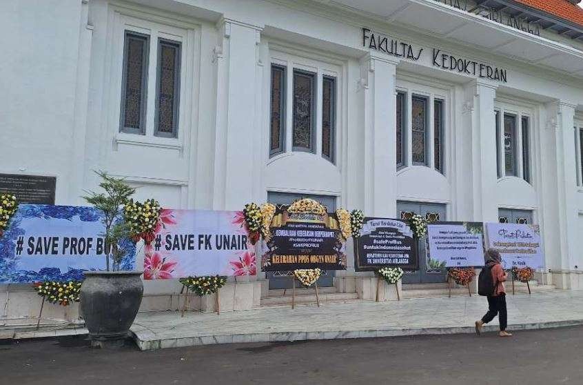 Karangan bunga memenuhi halaman Fakultas Kedokteran Unair Surabaya, sebagai bentuk membela dan dukungan untuk Prof Dr dr Budi Santoso SpOG FER atau akrab disapa Prof BUS. (Foto: Julianus Palermo/Ngopibareng.id)