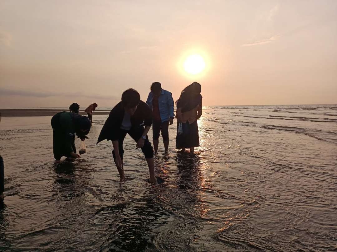 Wisatawan sedang berwisata sambil mencari kerang di Pantai Greenthing, Desa Randutatah, Kecamatan Paiton, Kabupaten Probolinggo. (Foto: Ikhsan Mahmudi/Ngopibareng.id)