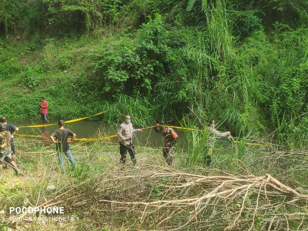 Polisi memasang garis polisi untuk evakuasi mayat bayi dalam tas ransel di sungai di Desa Jimbe Kecamatan Kademangan kabupaten Blitar, Selasa 9 Juli 2024.(Foto: dok. Polres Blitar)