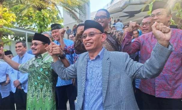 Prof Budi Santoso (kiri kemeja batik) dan Rektor Unair Prof Mohammad Nasih (kanan pakai jas) menandai perdamaian dengan bergandeng tangan. (Foto: Julianus Palermo/Ngopibareng.id)