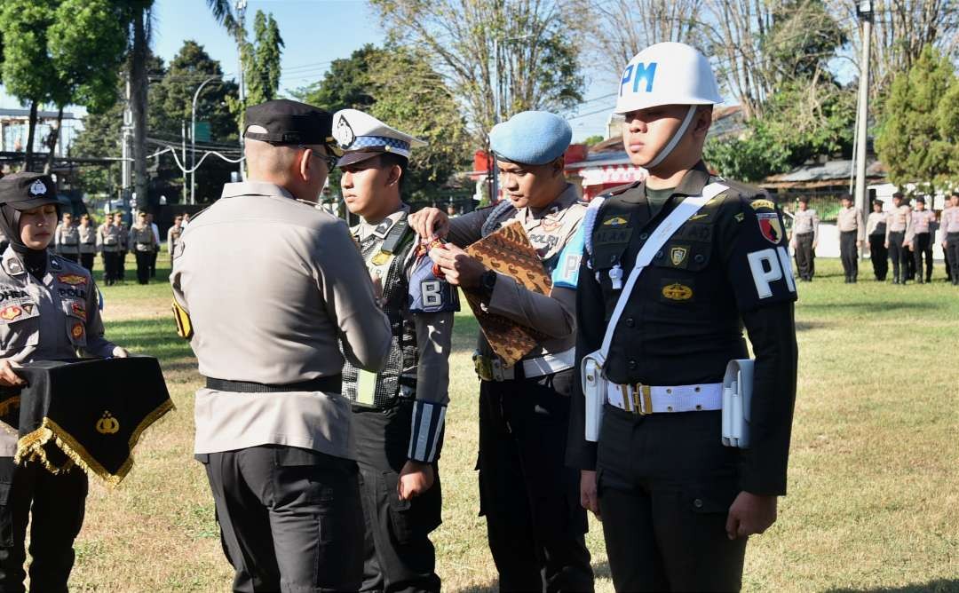 Kapolres Bondowoso, AKBP Lintar Mahardhono memasang tanda operasi patuh pada apel pasukan di Mapolres Bondowoso, Senin 15 Juli 2024. (Foto: Guido Saphan/Ngopibareng.id)