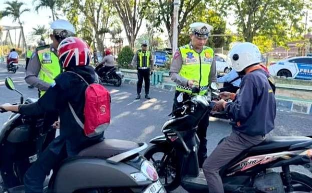 Anggota Satlantas Polres Situbondo memeriksa kelengkapan  surat pengendara motor dalam Operasi Patuh Semeru 2024, Selasa 16 Juli 2024.(Foto: Guido/Ngopibareng.id)