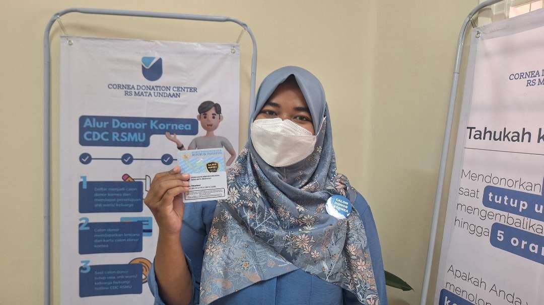 Staff Sekretariat CDC RS Mata Undaan Fitriah Oktafiani saat menunjukkan kartu identitas calon pendonor kornea dan KTP yang diberikan lencana khusus. (Foto: Julianus Palermo/Ngopibareng.id)