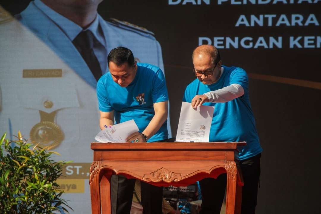 Walikota Surabaya Eri Cahyadi (kiri) dan Sekretaris Kementerian Koperasi dan UKM Arif Rahman Hakim, saat menandatangani nota kesepakatan komitmen pengembangan koperasi dan UMKM, dalam rangka peringatan Hari Koperasi ke-77. (Foto: Julianus Palermo/Ngopibareng.id)