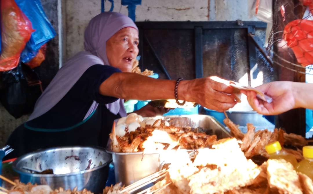 Bu Karmini usianya 84 tahun masih trengginas melayani pelanggan di warungnya. (Foto: Asmanu Sudarso/Ngopibareng.id)