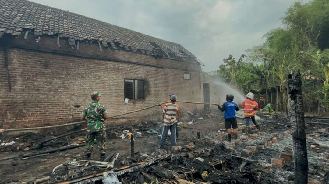 Petugas pemadam kebakaran dibantu warga melakukan pembasahan.(Foto Deni Lukmantara/Ngopibareng.id)