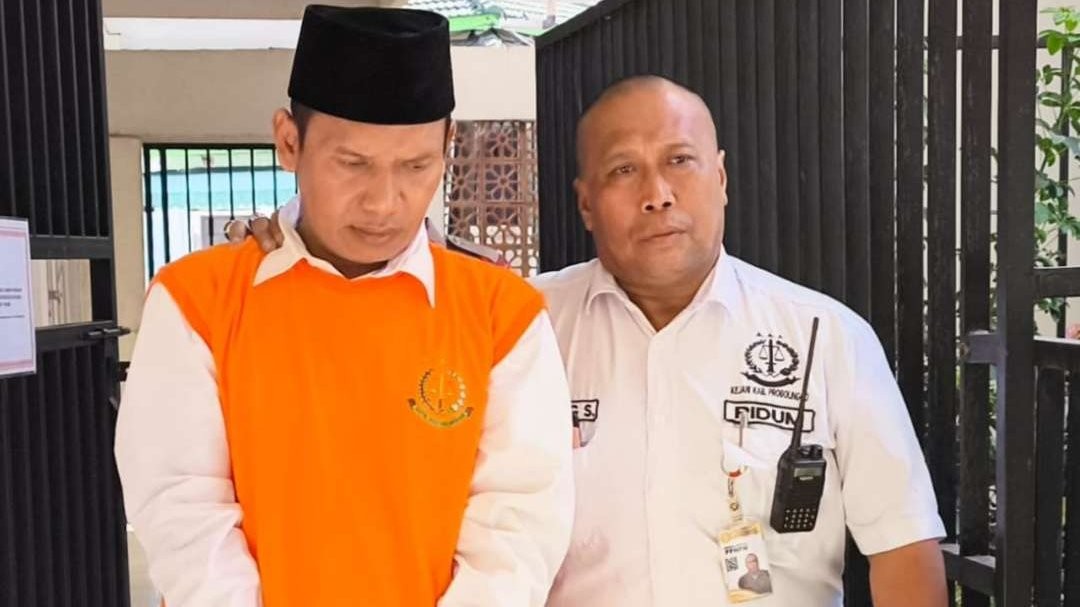 Sholehuddin, 54 tahun (kiri) saat digelandang menuju ruang sidang di PN Kraksaan. (Foto: Ikhsan Mahmudi/Ngopibareng.id)