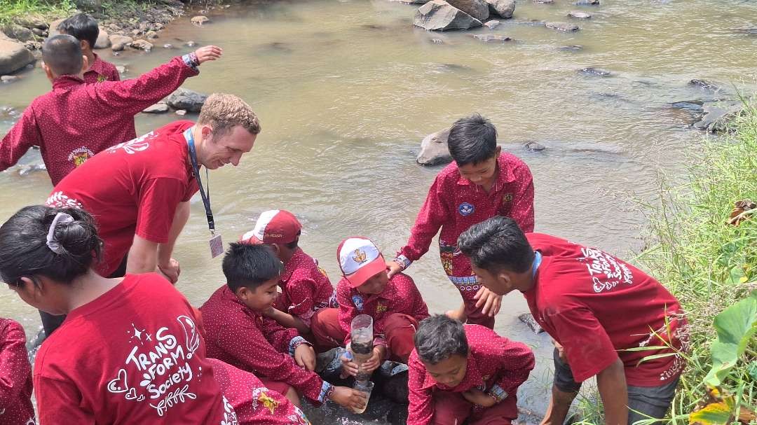 Tijl Olmo Rietdijk, mahasiswa dari Inholland Hogeschool-Belanda, saat bersama anak-anak di Dusun Petung, Sumberjati, Mojokerto, menggunakan filter air dalam ukuran mini. (Foto: Julianus Palermo/Ngopibareng.id)