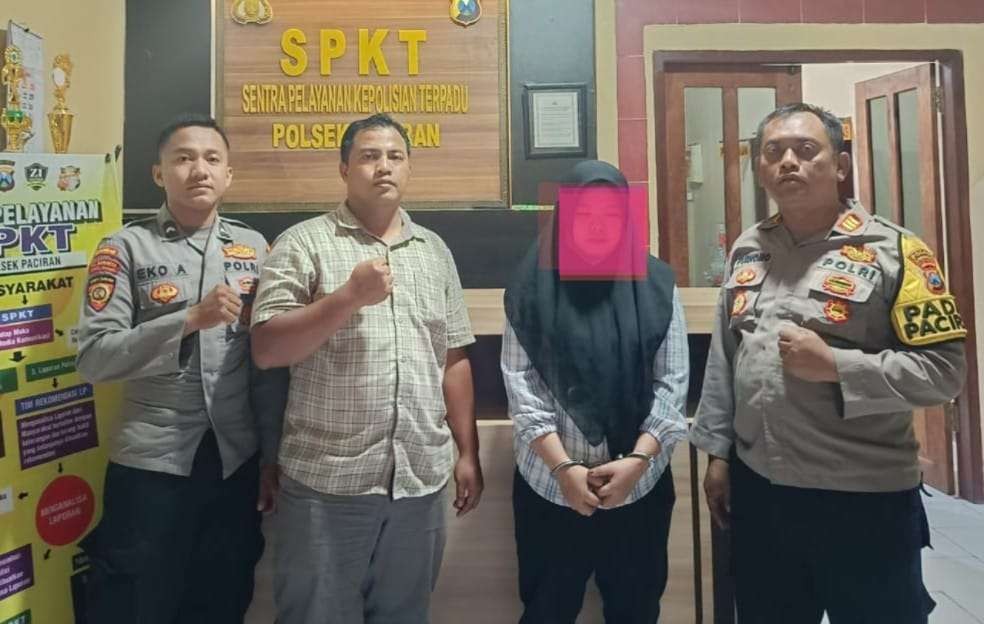 Pelaku Rev sedang diapit petugas dengan tangan terborgol. (Foto: Istimewa)