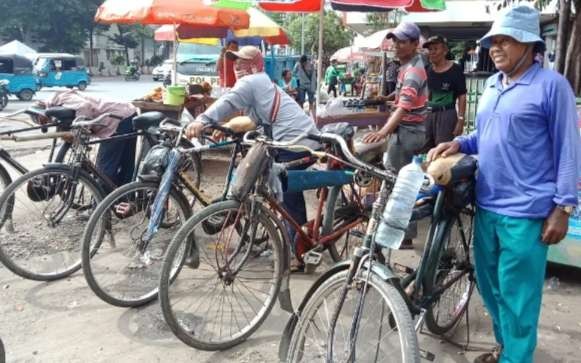 Tukang ojek sepeda ontel menunggu penumpang di kawasan Stasiun KA Tanjung Priok Jakarta Utara dengan sabar. (Foto: Asmanu Sudarso/Ngopibareng.id)