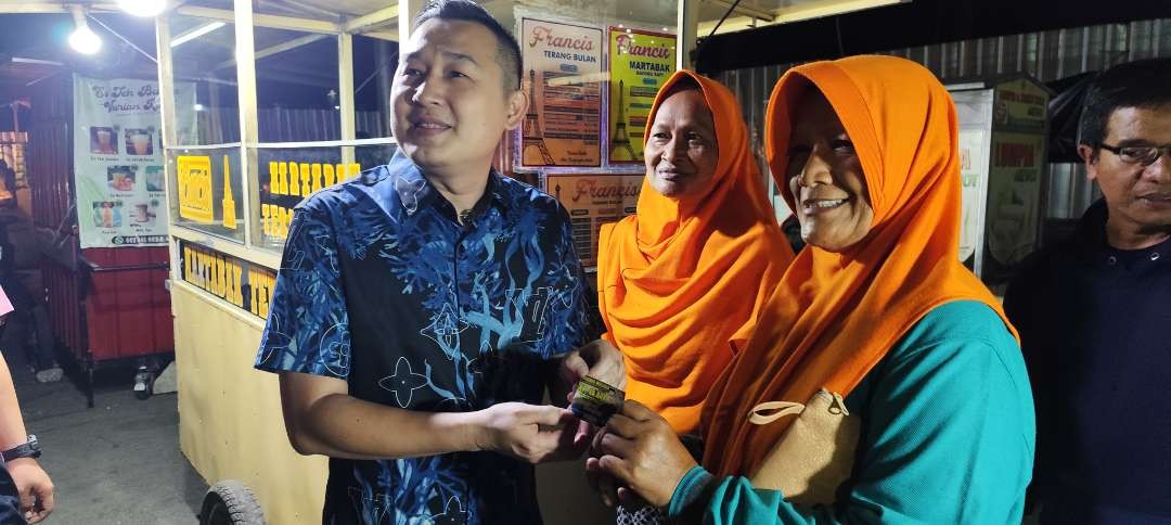 Ketua DPD PSI Kota Kediri Ronny Siswanto bagikan ratusan voucer belanja makanan dan minum gratis kepada warga di Alun-alun Kota. (Foto: Fendi Lesmana/Ngopibareng.id)