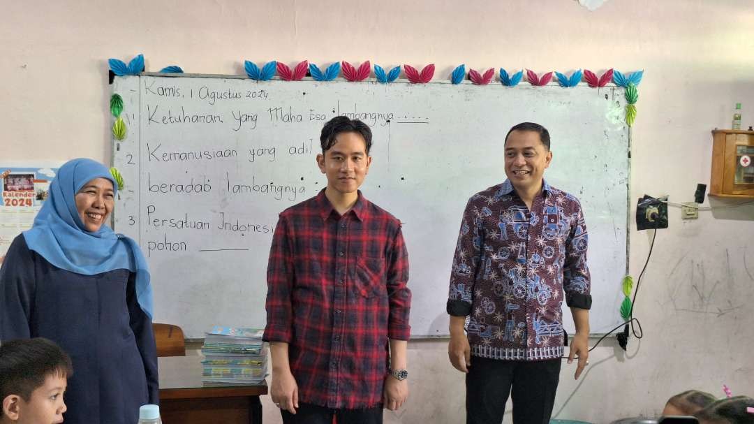 Wakil Presiden terpilih Gibran Rakabuming Raka (tengah) diapit Gubernur Jatim 2018-2024 Khofifah Indar Parawansa dan Walikota Surabaya Eri Cahyadi, saat simulasi makan bergizi gratis di SD Negeri Klampis Ngasem III Surabaya. (Foto: Julianus Palermo/Ngopibareng.id)