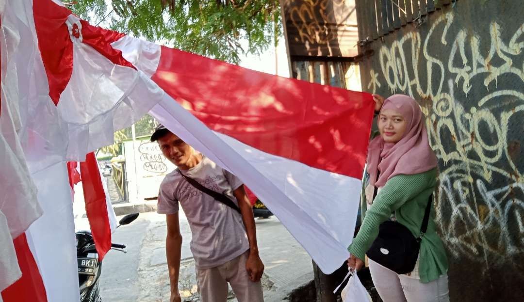 Penjualan bendera keliling sepi pembeli kalah dengan toko online (Foto: Asmanu Sudarso/ngopibareng.id)