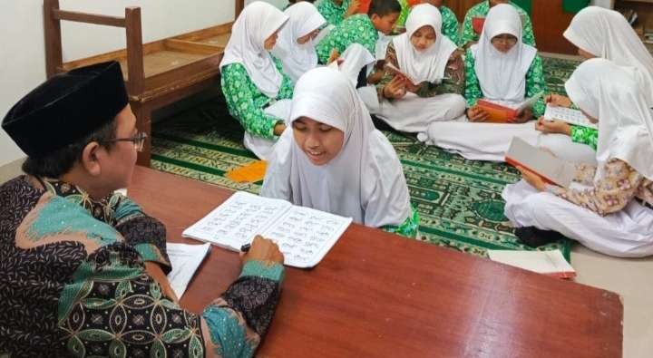 Salah satu guru Qiroati Masyhuri mengajar cara membaca Alquran yag benar kepada muridnya (Foto: Asmanu Sudarso/ngopibareng.id)