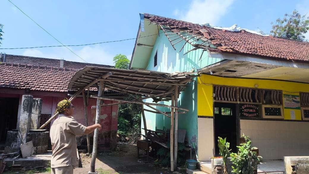 Kepala SDN Bimo, M. Juri menunjukkan kondisi kelas VI SDN Bimo, Kecamatan Pakuniran, Kabupaten Probolinggo yang rusak parah. (Foto: Ikhsan Mahmudi/Ngopibareng.id)