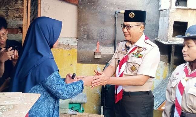 Ketua Kwartir Nasional (Kwarnas) Gerakan Pramuka, Budi Waseso, menerima ucapan terima kasih dari Ibu Kamsiah, warga Kebon Bawang, Tanjung Priok, Jakarta Utara, rumah masuk program bedah rumah Gerakan Pramuka. (Foto: Asmanu Sudarso/Ngopibareng.id)