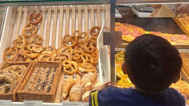 Cucu penulis sedang mengamati roti Brezel yang ada di atalase di Leverkusen, Jerman. (Foto:Ngopibareng.Id/Sukemi)