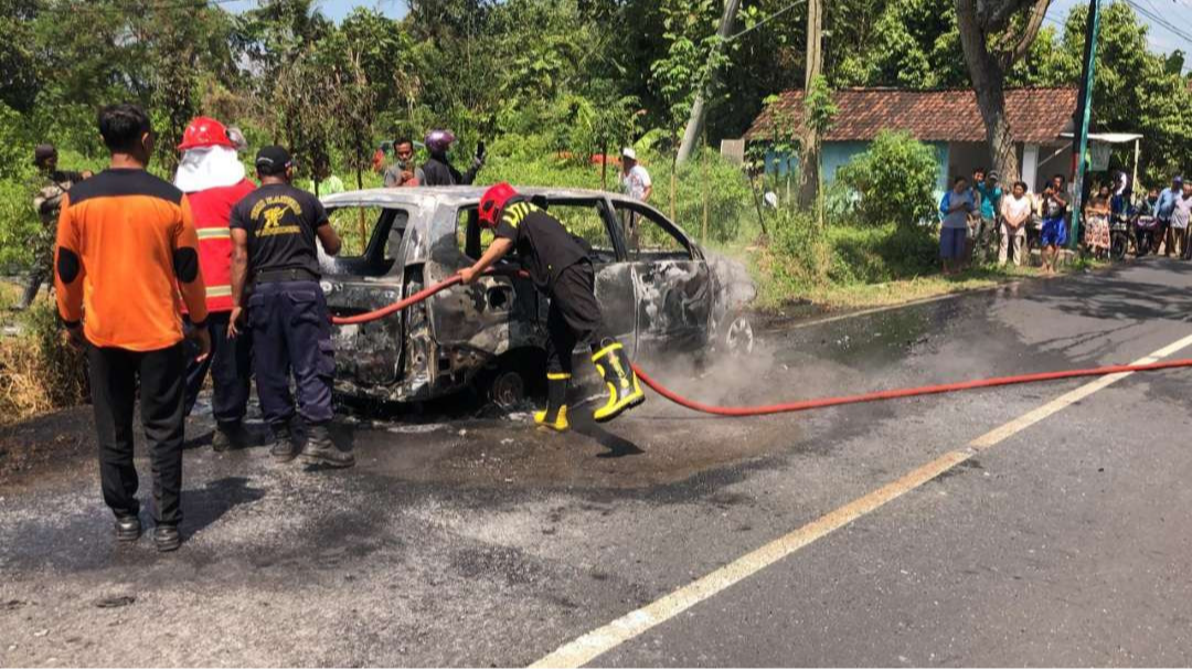 Petugas pemadam kebakaran memadamkan api pada mobil.(Foto: istimewa)