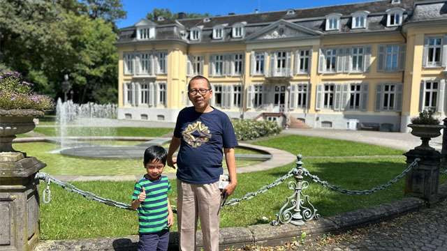 Sukemi, penulis, foto bersama cucunya dengan latar belakang  Schloss Morsbroich di Kota Leverkusen, Jerman, sebuah kastil barok yang dibangun pada abad ke-18. (Foto: Ngopibareng.Id/Sukemi)