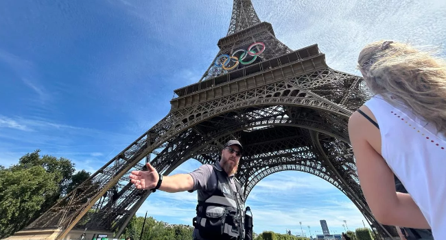 Petugas mengevakuasi wisatawan pasca ditangkapnya seorang warga Inggris yang memanjat menara Eiffel. (Foto: Mirror)