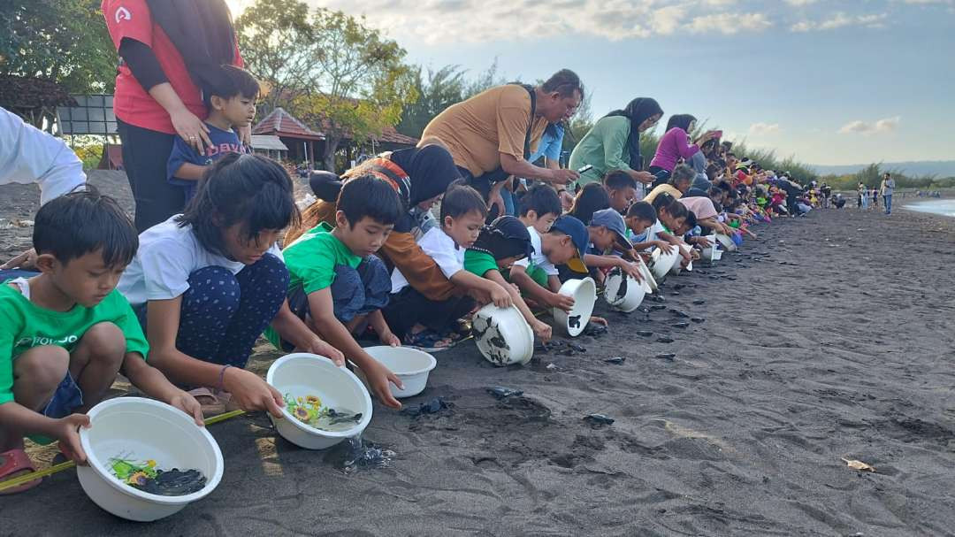 Ratusan anak-anak melepasliarkan penyu di pantai Pulau Santen Banyuwangi (Foto: Muh Hujaini/Ngopibareng.id)