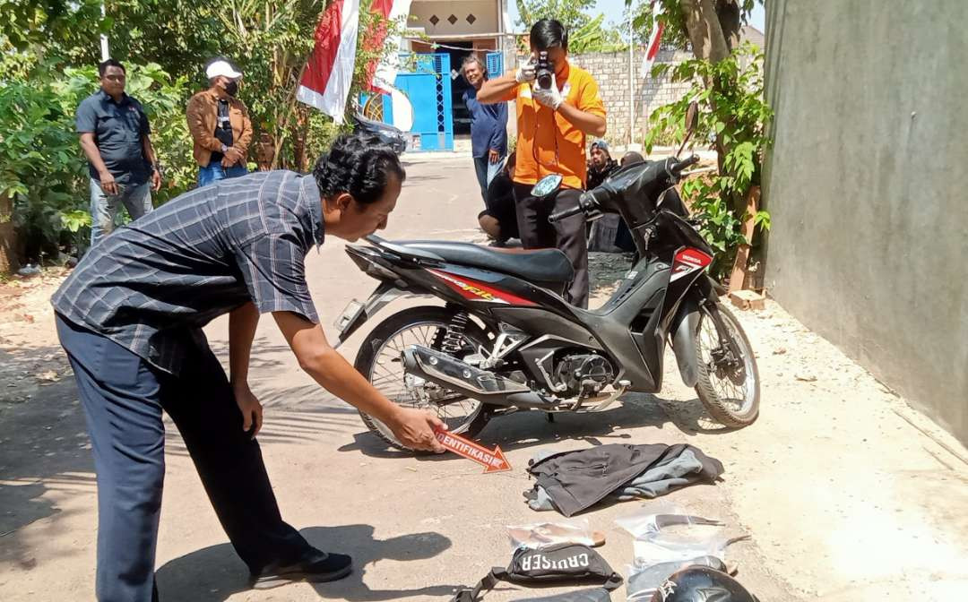 Petugas kepolisian melakukan proses identifikasi di lokasi kejadian pembunuhan (Foto: Khoirul Huda/Ngopibareng.id)