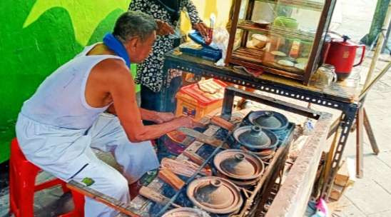 Nasuha sibuk dengan dapur serabi kampung yang ditekuni puluhan tahun, tetap semangat karena banyak pembeli (Foto; Asmanu Ngopibareng.id)