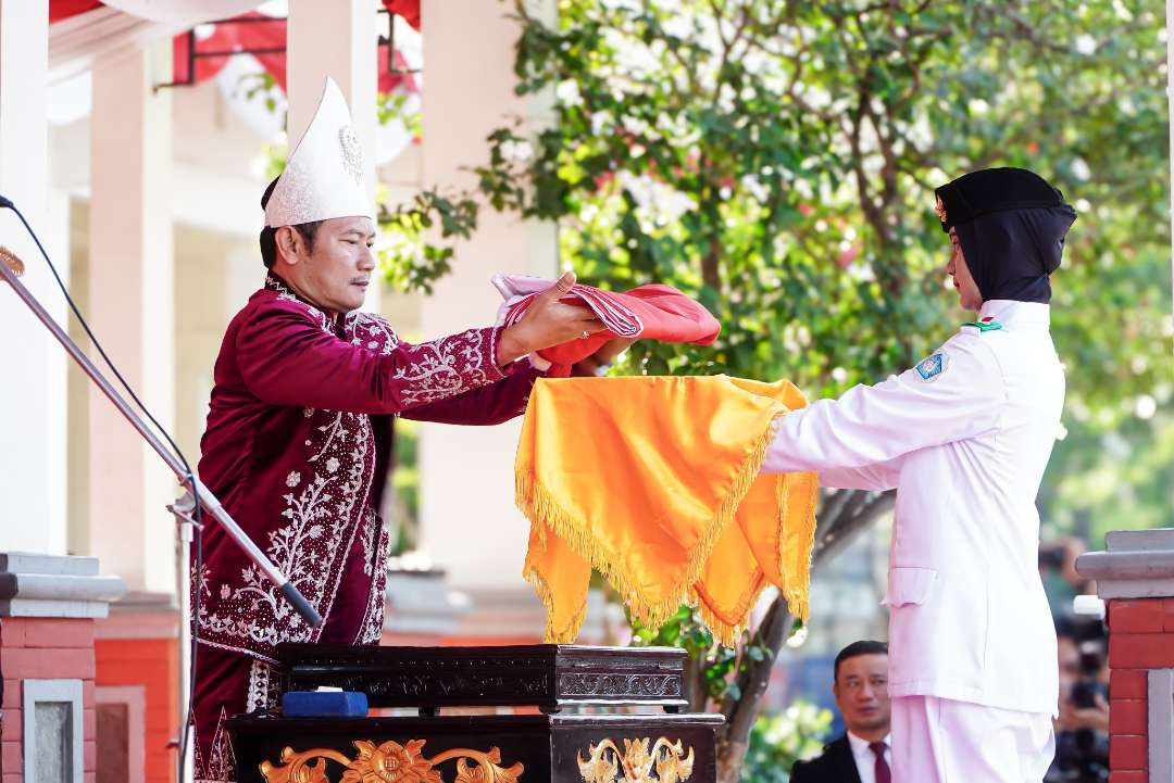 Bupati Lamongan saat menyerahkan bendera merah putih sebelum dilkibarkan (Foto : Istewa) n