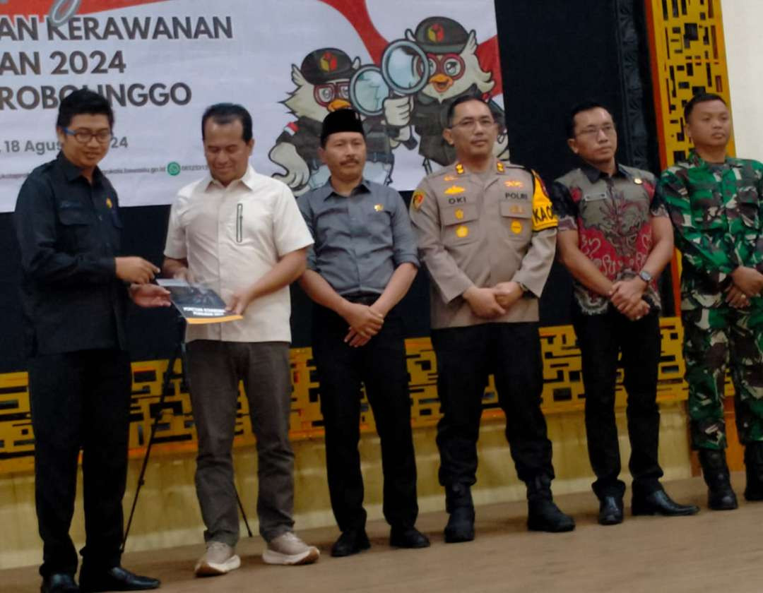 Ketua Bawaslu Kota Probolinggo, Johan Dwi Angga menyerahkan buku Pemetaan Potensi Kerawanan Pemilu Kota Probolinggo kepada jajaran Forkopimda. (Foto: Ikhsan Mahmudi/Ngopibareng.id)