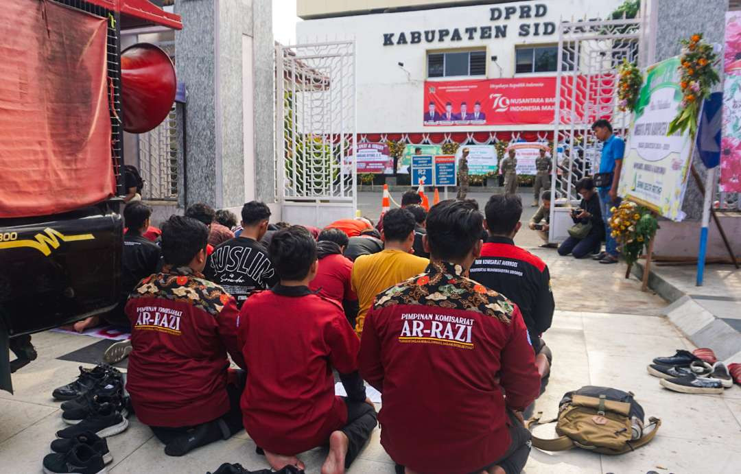 Mahasiswa IMM sholat berjamaah di depan Kantor DPRD Kabupaten Sidoarjo (Foto : Aini/Ngopibareng.id)