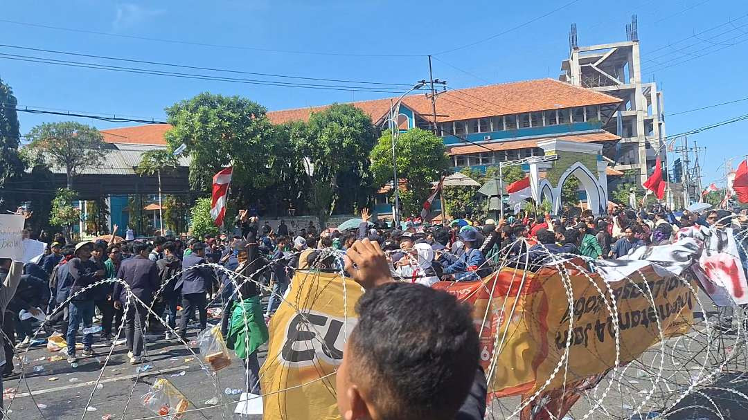 Massa aksi diduga melakukan pelemparan botol ke arah petugas kepolisian dan Gedung DPRD Jatim, dalam demonstrasi mengawal Putusan MK dan penolakan perubahan UU Pilkada, Jumat 23 Agustus 2024. (Foto: Julianus Palermo/Ngopibareng.id)