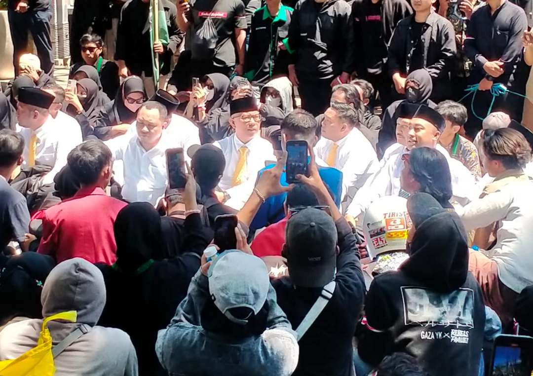 Para mahasiswa dan anggota DPRD Kota Probolinggo duduk lesehan di jalan saat berdemo terkait putusan MK. (Foto: Ikhsan Mahmudi/Ngopibareng.id)