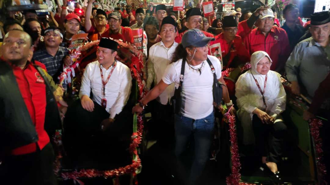 Pasangan Tri Rismaharini (kanan) dan Gus Hans (kiri) diantar naik becak lakukan pendaftaran ke KPU Jatim, Kamis 29 Agustus 2024. (Foto: Fariz Yarbo/Ngopibareng.id)