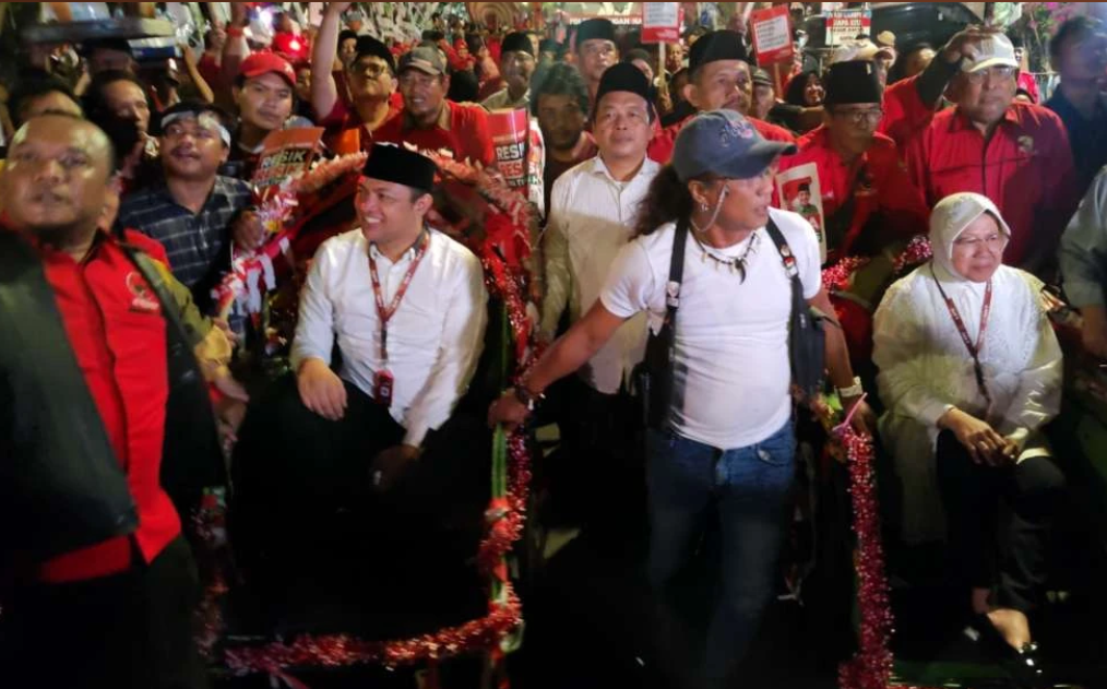 Pasangan Tri Rismaharini (kanan) dan Gus Hans (kiri) diantar naik becak lakukan pendaftaran ke KPU Jatim, Kamis 29 Agustus 2024. (Foto: Fariz Yarbo/Ngopibareng.id)