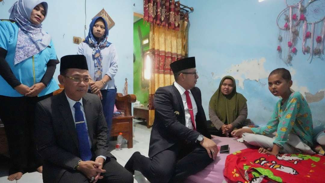 Pj Wali Kota Mojokerto didampingi Sekdakot mengunjungi warga yang menderita tumor uterus. (Foto: Deni Lukmantara/Ngopibareng.id)