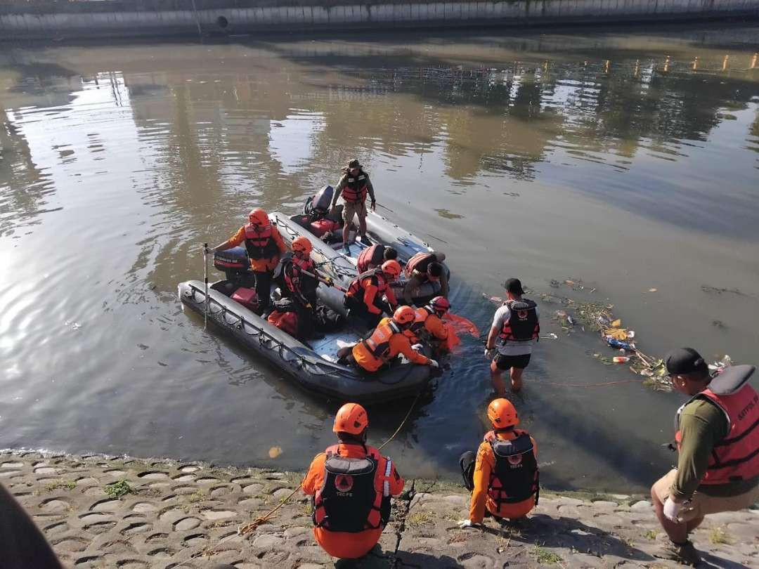 Petugas gabungan evakuasi mayat seorang pria yang ditemukan mengambang di Sungai Kalimas, Genteng, Surabaya. (Foto: Polsek Genteng)