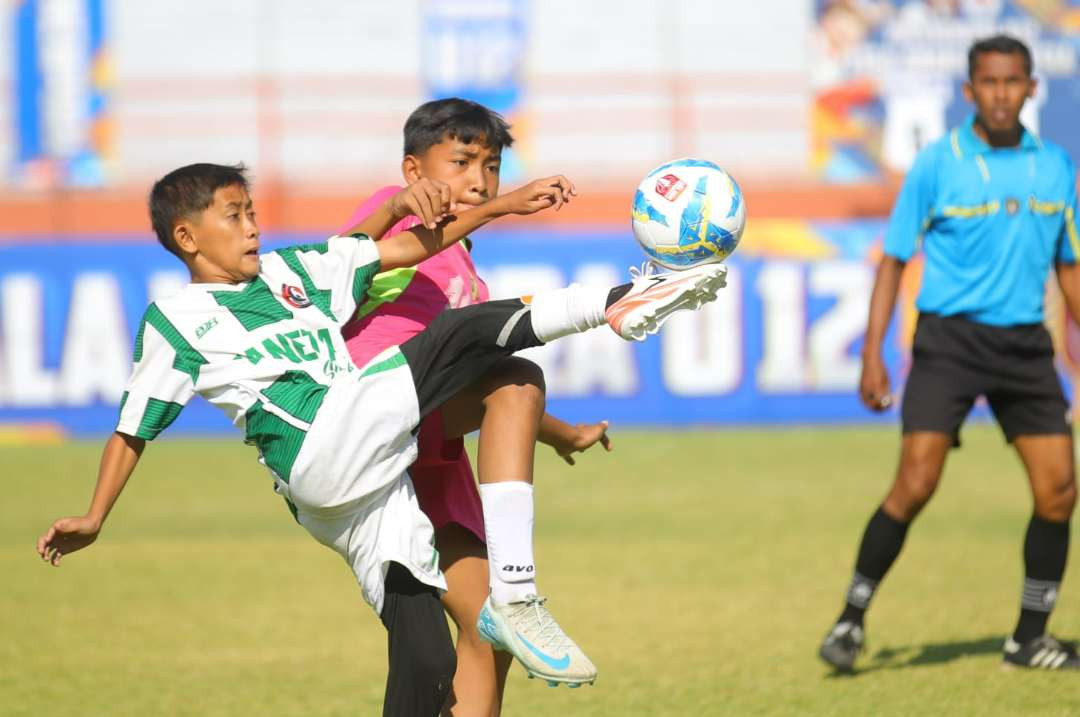 Dua pemain dari tim peserta Liga Anak Indonesia saat bertanding di Surabaya. (Foto: Kemendpora)