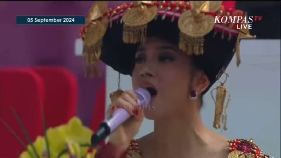 Penyanyi Lyodra menyanyikan lagu rohani dibalut busana adat Batak Karo warna merah, sebelum dimulainya misa akbar dipimpin Paus Fransiskus di Stadion Utama Gelora Bung Karno (SUGBK) Senayan Jakarta, Kamis 5 September 2024. (Foto: Tangkapan layar Kompas TV)