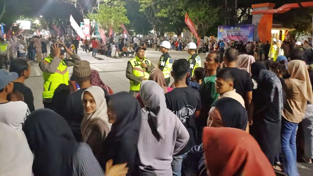 Ratusan warga saat akan menyambut kedatangan Presiden Joko Widodo dalam pembukaan PON XXI 2024 di Stadion Harapan Bangsa, Banda Aceh, Senin 9 September 2024 malam. (Foto: Fariz Yarbo/Ngopibareng.id)