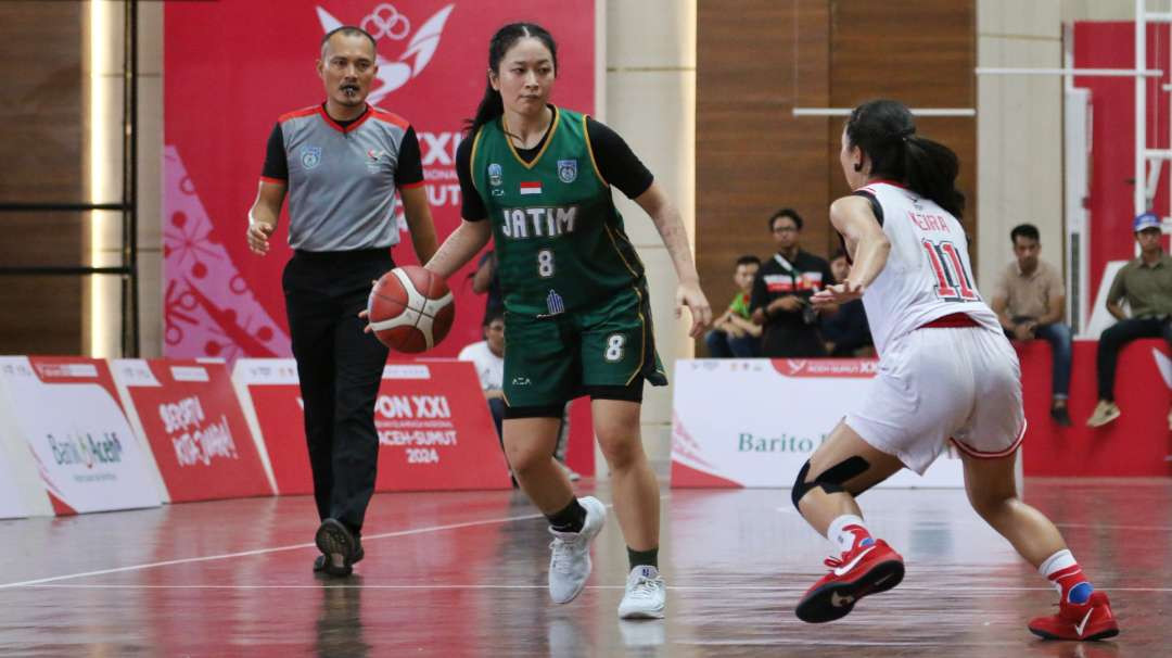 Pebasket Putri Jatim, Evelyn Fiyo (hijau) saat melawan DKI Jakarta pada babak final PON XXI 2024 Aceh-Sumut. (Foto: Fariz Yarbo/Ngopibareng.id)