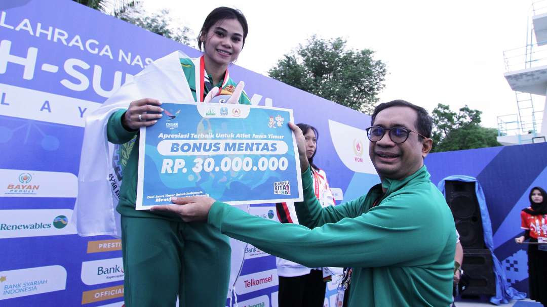 Ketua POSSI Jatim, Mirza Muttaqien memberikan bonus mentas kepada Janis Rosalita usai memenangkan lomba 100 meter surface putri pada PON XXI 2024 Aceh-Sumut di Kolam Tirta Raya, Banda Aceh, Rabu 11 September 2024. (Foto: Fariz Yarbo/Ngopibareng.id)